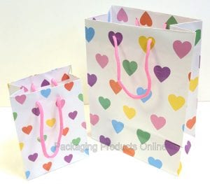 Two white gift bag with handles, printed with lots pastel coloured hearts