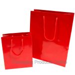 A small and medium sized glossy red gift bag with red cord handles.